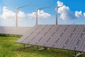Alternative and renewable energy production concept. Photovoltaic solar panels and wind turbines at power plant. Royalty Free Stock Photo