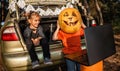 Online Halloween celebration. Kids scaring friends via internet at themed party in trunk of car