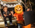 Online Halloween celebration. Kids scaring friends via internet at themed party in trunk of car