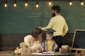 Alternative study. Mother teaches clever son, while father writes on chalkboard on background. Boy listening to mom with Royalty Free Stock Photo