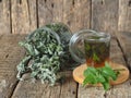 Alternative traditional medicine.Dried leaves of Melissa or mint with a fresh twig and decoction in a glass on an ancient wooden