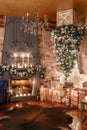 Alternative tree upside down on the ceiling. Winter home decor. Modern loft interior with fireplace and brick wall