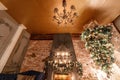 Alternative tree upside down on the ceiling. Winter home decor. Modern loft interior with fireplace and brick wall Royalty Free Stock Photo