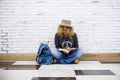 Alternative trendy travel people lifestyle beautiful curly fashion adult woman sit down on the floor and read a booko with her