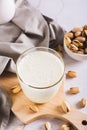 Alternative vegetarian pistachio milk in a glass and nuts on the table vertical view Royalty Free Stock Photo