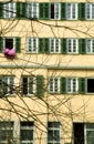 Old house - purple bedding hangs from a window for ventilation