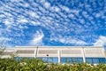 Altocumulus clouds hover over a modern office building on a bright afternoon