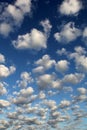 Altocumulus white puffy fluffy clouds against deep blue sky