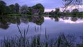 Reflections of St Leonard`s church in Hartley Mauditt Pond, South Downs National Park, UK