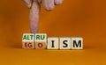 Altruism or egoism symbol. Businessman turns wooden cubes and changes the word `egoism` to `altruism`. Beautiful orange backgr