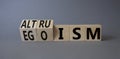 Altruism and Egoism symbol. Turned wooden cubes with words Egoism and Altruism. Beautiful grey background. Business, psychological