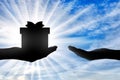 Altruism. Silhouette of hand giving gift and hand receiving gift Royalty Free Stock Photo