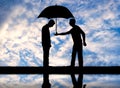 Altruist man gives his umbrella to another sad man standing in the rain
