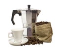 Aluminium moka pota, white ceramic coffee cup and burlap sack overflowing with roasted coffee beans in white background.