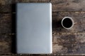 Aluminium Notebook (laptop) with cup of hot coffee on wood table.