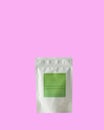 Aluminum bag for tea, coffee, condiments and other bulk substances with green label for signature on pink background Royalty Free Stock Photo