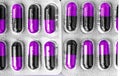 Aluminum blisters with colored black and purple oval capsules neat flat lay