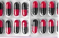 Aluminum blisters with colored black and red oval capsules neat flat lay