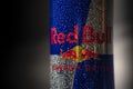 Aluminum can of RedBull drink with water drops over dark background. Red Bull is the most popular energy drink in the world Royalty Free Stock Photo