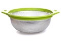 aluminum colander with plastic light green handles on a white isolated background