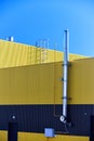 Aluminum composite panels yellow and blue commercial building facade with stainless steel chimney pipe and natural gas Royalty Free Stock Photo