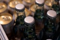 Aluminum crown caps on glass beverage bottles at a grocery or supermarket.