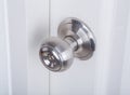 Aluminum door knob on white door