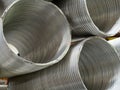 Aluminum duct sections sitting on top of each other in indoor storage area Royalty Free Stock Photo