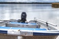 Aluminum fishing boat close up front view, in the background a blurred background of the sea and forest.