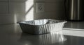Aluminum Foil Baking Pan on Countertop with Dramatic Light and Shadow Royalty Free Stock Photo