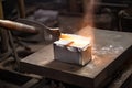 aluminum ingot being forged into shape by hammer and anvil