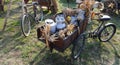 aluminum milk cans brimming with fresh farm produce nestled in wooden cart with bike Royalty Free Stock Photo