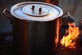 aluminum pan on wood burning stove with flame next to it