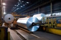 aluminum rolling mill, with massive rolls of metal being fed into the production process