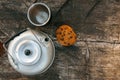 Aluminum teapot , cup and oatmeal cookies with chocolate on dry wooden table. Flat lay food. Picnic. Outdoor cooking. Kettle. Picn