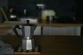 Aluminum traditional coffee maker on the table in the interior of the kitchen in a low key Royalty Free Stock Photo