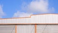 Aluminum ventilation louvers on corrugated steel wall of modern industrial warehouse building against blue sky background Royalty Free Stock Photo