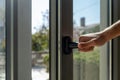 Aluminum window frame detail. Male hand opens the metal door closeup view Royalty Free Stock Photo