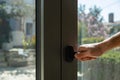 Aluminum window frame detail. Male hand opens the metal door closeup view Royalty Free Stock Photo