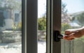 Aluminum window frame detail. Male hand opens the metal door closeup view Royalty Free Stock Photo