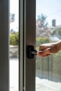 Aluminum window frame detail. Male hand opens the metal door closeup view Royalty Free Stock Photo