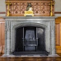 Marble fireplace with the old English clock on the background of the carved wood in the Vorontsov Palace in Alupka, Russia