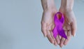 Alzheimer`s Disease AD Awareness with purple ribbon clipping path on human helping hand for World Alzheimers day month