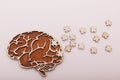 Alzheimer's disease and mental health concept. Brain and wooden puzzle on a pink background