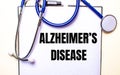 ALZHEIMERS DISEASE is written on a white sheet near the stethoscope. Medical concept Royalty Free Stock Photo
