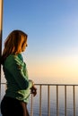 Amalfi - Woman enjoying a warm sunset at the Amalfi Coast in Italy from her hotel window