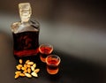 Amaretto, hazelnut liqueur in a glass decanter and two shot glasses on a black background Royalty Free Stock Photo