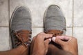 Detail of the hands of a young Brazilian man tying the tennis shoe Royalty Free Stock Photo