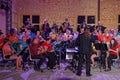 An amateur brass orchestra plays with a rock band