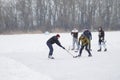 Amateur pair young and senior men playing hockey on a frozen river Dnipro in Ukraine